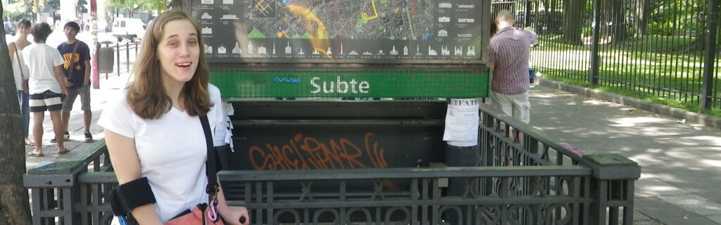 Antonia stands in front of a subway station in Argentina.