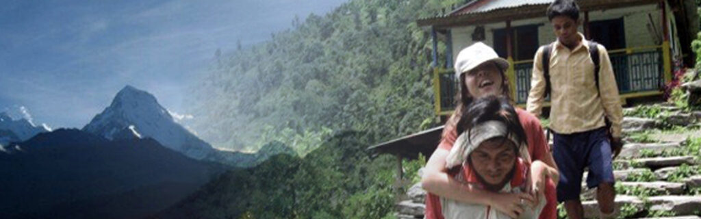 Megan Smith being carried on a man's back in Nepal