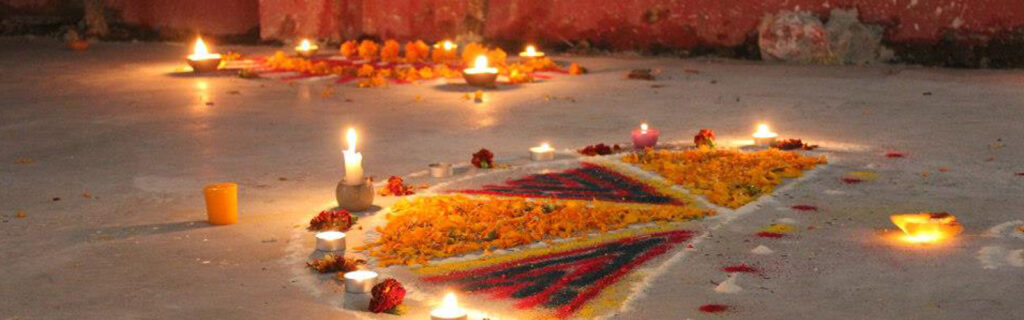 Celebrating Diwali - colorful flowers and sand with candles on the ground for this festival of lights