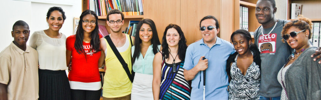 Exchange group with one person holding a white cane smiles for the camera.
