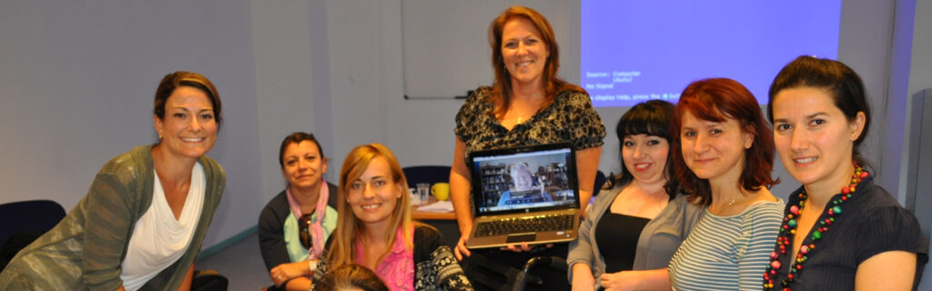 Team Macedonia of seven women gathered around laptop