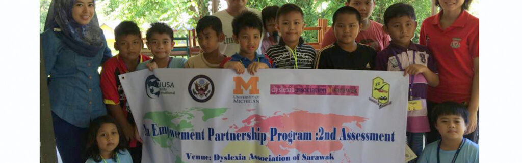 Children holding banner for Empower reading camp