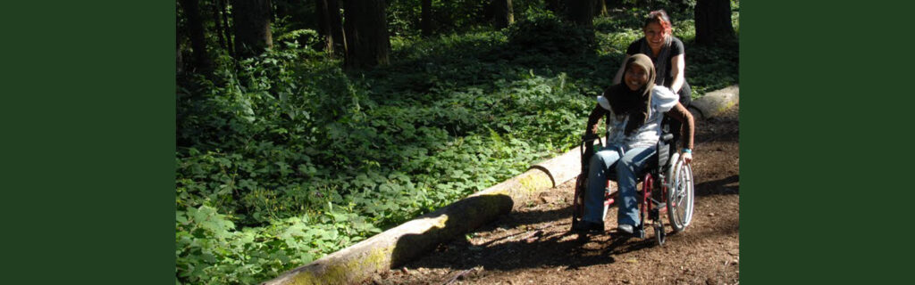 Woman in wheelchair gets a push from a friend.