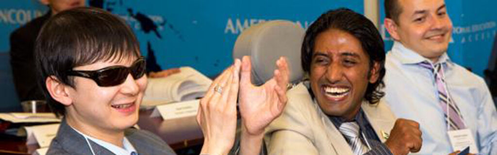 Three international men with disabilities clap and cheer.