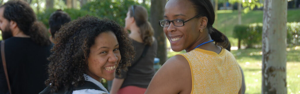 Two young American women smile looking over their shoulders.