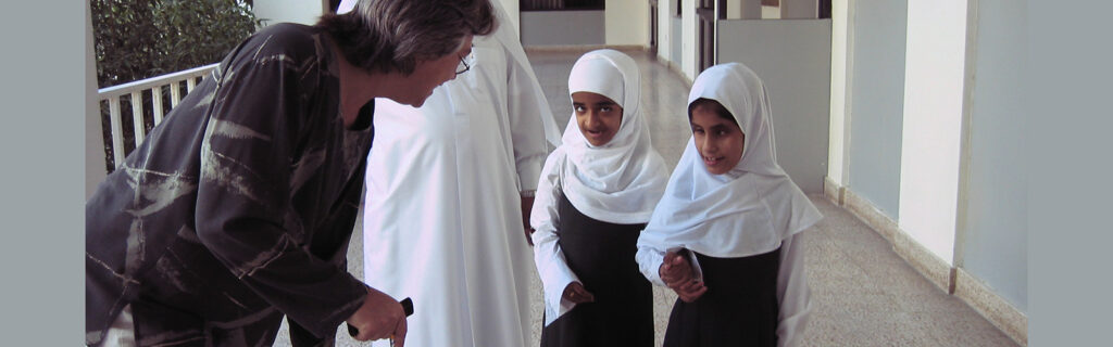 An American exchange participant talks with two young female students.