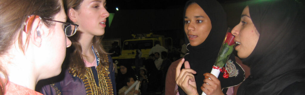 A group of four women are communicating with each other in sign language.