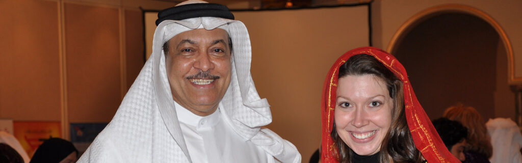 A Muslim man with an American woman dressed in red head scarf smile.