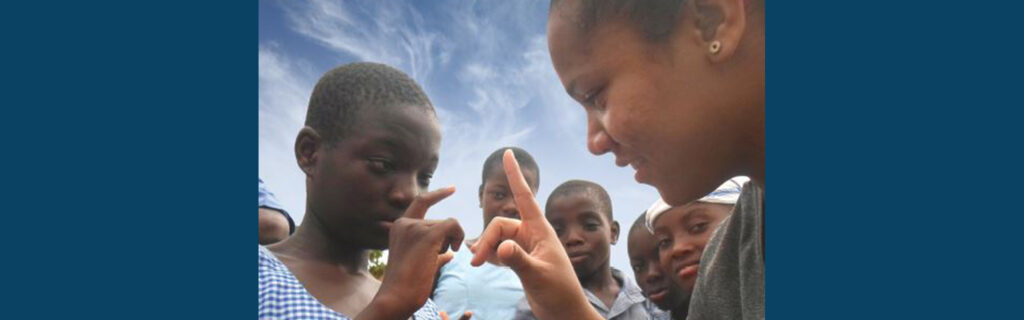 U.S. Deaf Volunteer teaches a sign to a Deaf African student