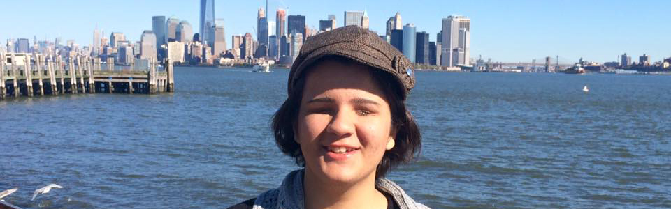 Pinar smiling in front of the New York City skyline