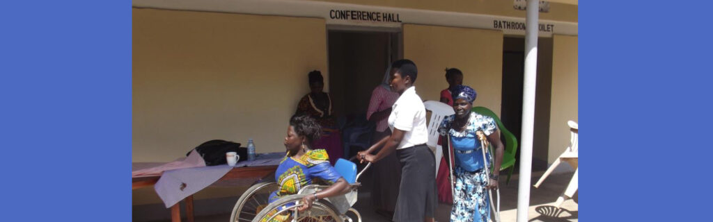South Sudan women, including one in a wheelchair and one with crutches, come outside from a conference room