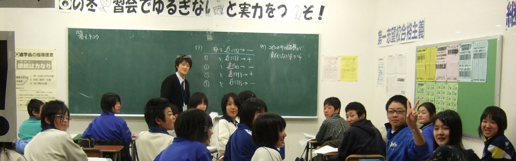 View of a Japanese classroom through a window; a teacher at a chalkboard