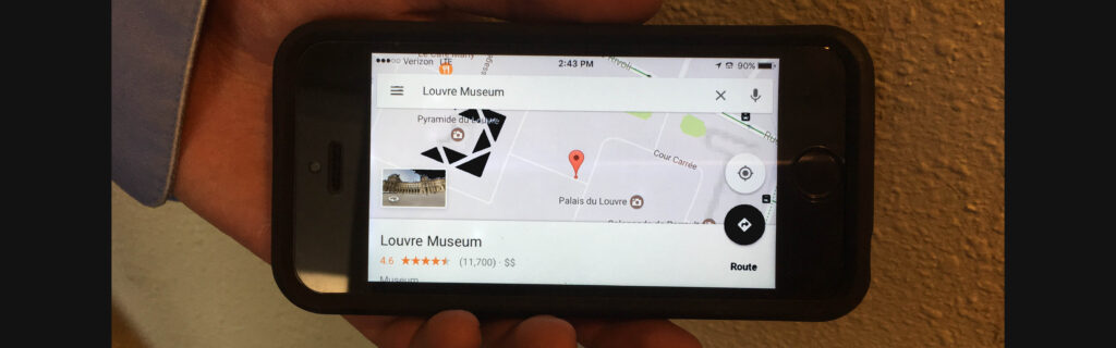 Hand holds iPhone with Google map on screen