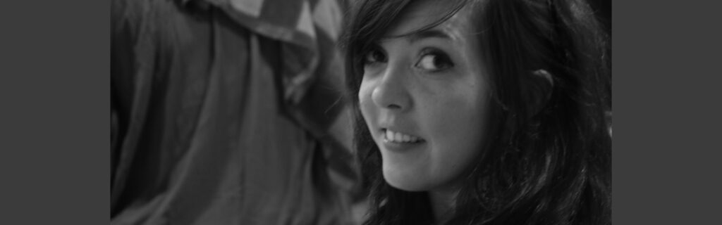 Megan close up in black and white, looking over her shoulder