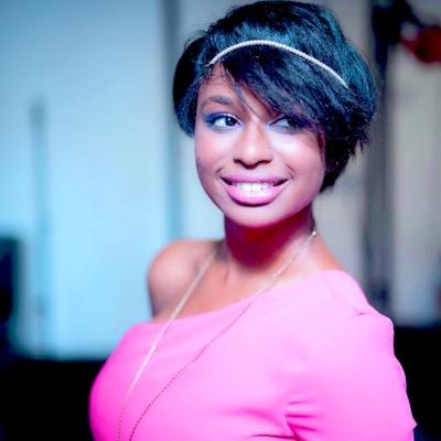 Professional portrait of Michelle Morris, a young black woman smiling and glancing sideways, wearing pink top