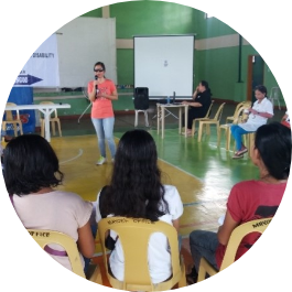 Workshop participants seated in a circle listening to the facilitator.