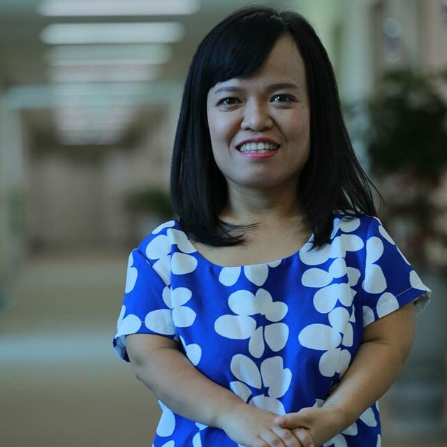 Chau little person, side bangs shoulder length straight black hair, Wearing a blue dress with white pocka dots.