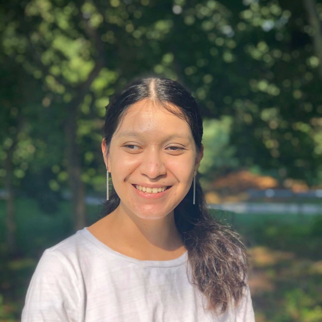 Portrait of Emely from shoulders up in an outdoor setting.