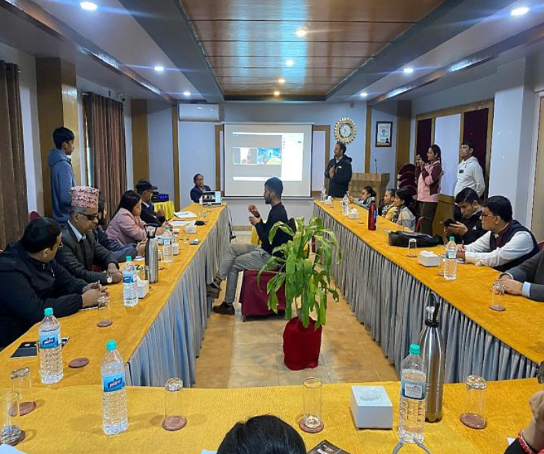 Group of people sitting around long U-shaped conference table having a discussion.