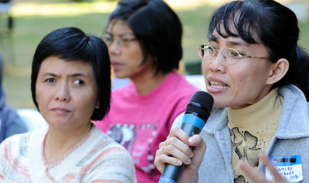 A disabled woman from Cambodia speaks into a microphone.