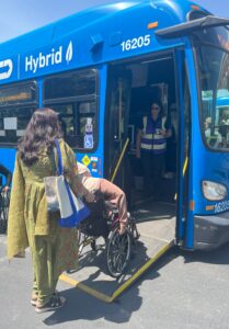 Two WILD delegates boarding an accessible public bus using the ramp.
