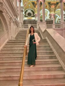 Karine wearing dark green gown, standing on the flight of stairs