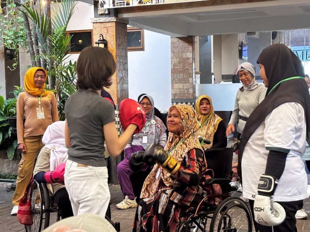 A WILD Muay Thai session in Indonesia. Participants in wheelchairs wear boxing gloves.